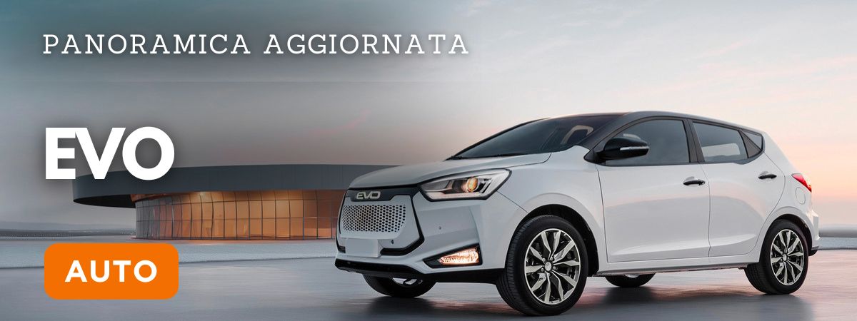 Veduta esterna della EVO auto modello 3 di colore bianco con nello sfondo una costruzione di cemento e vetro dal design moderno Trovala da Reduzzi Motor a Treviglio